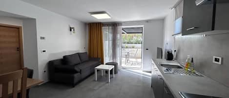 A modern kitchen with a built-in oven and a dining area with a wooden table and chairs.