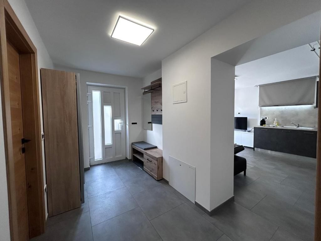 A modern kitchen with a built-in oven, a countertop, and a window.