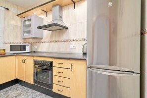 A kitchen with a microwave, oven, dishwasher, and a stainless steel refrigerator. - AP429 CASA ANGELINES (Nerja)
