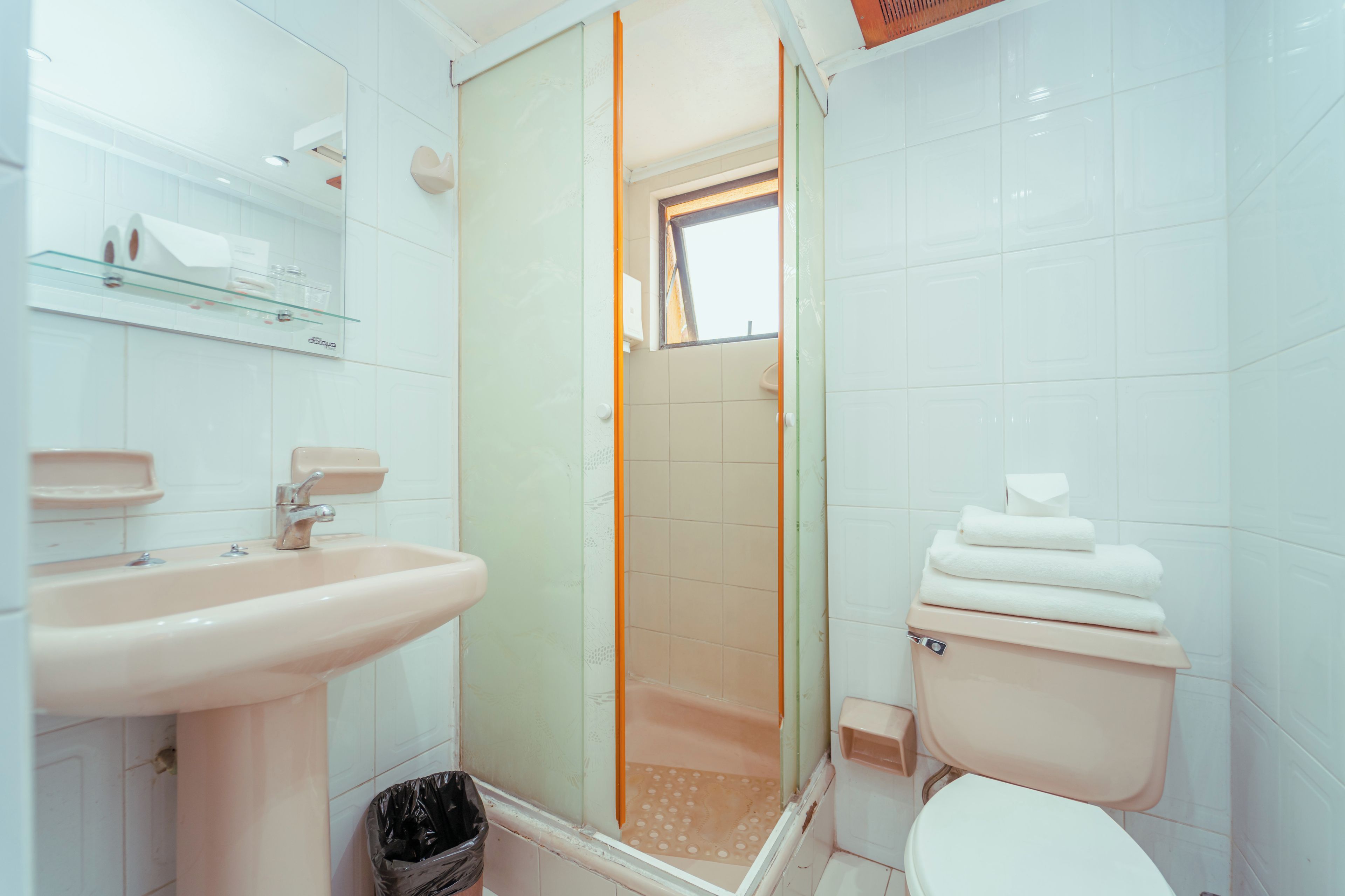 Une salle de bain comprenant un lavabo, des toilettes et un espace douche.