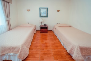 A hotel room with two beds, a nightstand, a lamp, and a framed picture on the wall. - Hotel Francisco de Aguirre Costa (La serena)