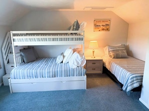 A bedroom with bunk beds, a bedside table with a lamp, and a poster on the wall. - New to our 2027 Inventory! Amazing views of Bass River Marina (West Dennis)