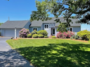 A single-story house with a front yard, a garage, and a driveway. - New to our 2027 Inventory! Amazing views of Bass River Marina (West Dennis)