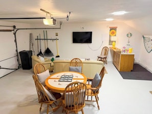 A compact living space with a dining area, a sofa, a television, and a small kitchen area. - New to our 2027 Inventory! Amazing views of Bass River Marina (West Dennis)