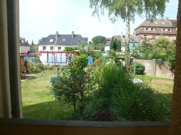 A residential area with houses, a grassy yard, and a tree.
