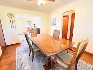 A dining area with a wooden table and chairs, a patterned rug, and a ceiling fan. - Comfort & convenience near Cleveland attractions! (Parma)