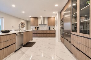 A modern kitchen with wooden cabinets, stainless steel appliances, and a marble countertop. - Private Oasis 5 Bed 4 Bth w Heated Pool Great for Families and Large Groups (Miami)