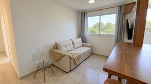 Ein Wohnzimmer mit einer Couch, einem Sessel und einem Holztisch.