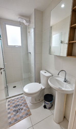 Ein Badezimmer mit Toilette, Bidet, Waschbecken und einer Duschkabine.