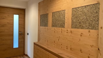 A wooden interior with a door, a wall with a textured panel, and a wooden counter.