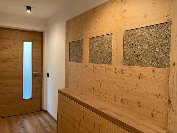 A wooden interior with a door, a wall with a textured panel, and a wooden counter. - Apartment 'Pe De Munt Mez Col' with Mountain View, Balcony and Wi-Fi (La Valle)
