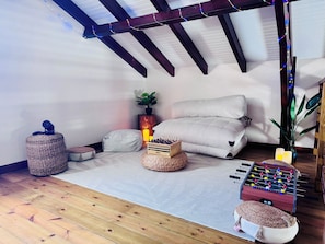 A cozy room with a foosball table, a sofa, and a plant. - Villa Between Land and Sea (Les Anses-d'Arlet)