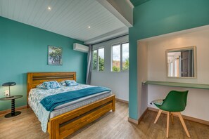 A bedroom with a wooden bed, a desk, a chair, and a window with curtains. - Villa Galéa - Climatisée, vue mer, piscine (Etang-Salé les Hauts)