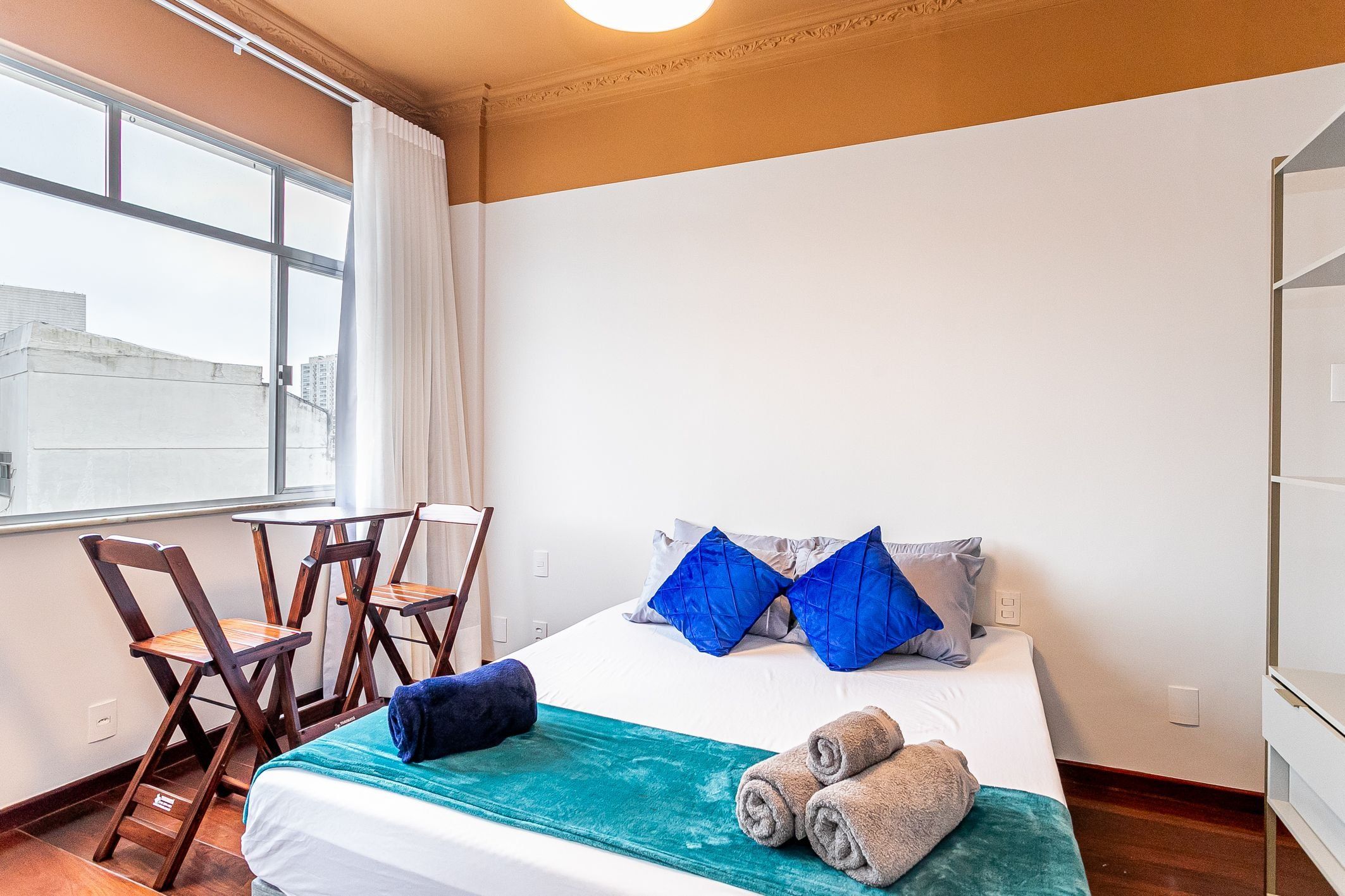 A hotel room with a bed, a desk, and chairs.