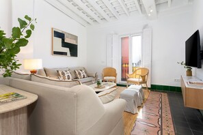 A modern living room with a sofa, chairs, a coffee table, and a television. - Genteel Home Patio del Arenal 201 (Seville)
