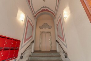 A staircase with a handrail, a red mailbox, and a door at the top. - Sunflower Suite by MMega (Firenze)