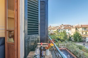A balcony with a wooden table, wine glasses, and a vase with flowers. - Sunflower Suite by MMega (Firenze)