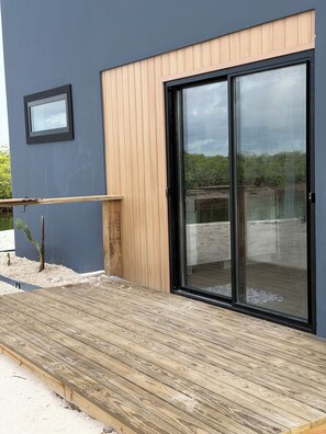 A modern building with a wooden exterior, a sliding glass door, and a small window. - Cozy 1-bedroom apartment in peaceful Casuarina with AC (Casuarina)