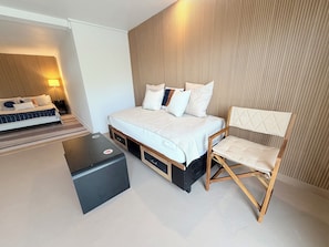 A modern bedroom with a bed, bedside tables, a chair, and a lamp. - Cozy 1-bedroom apartment in peaceful Casuarina with AC (Casuarina)