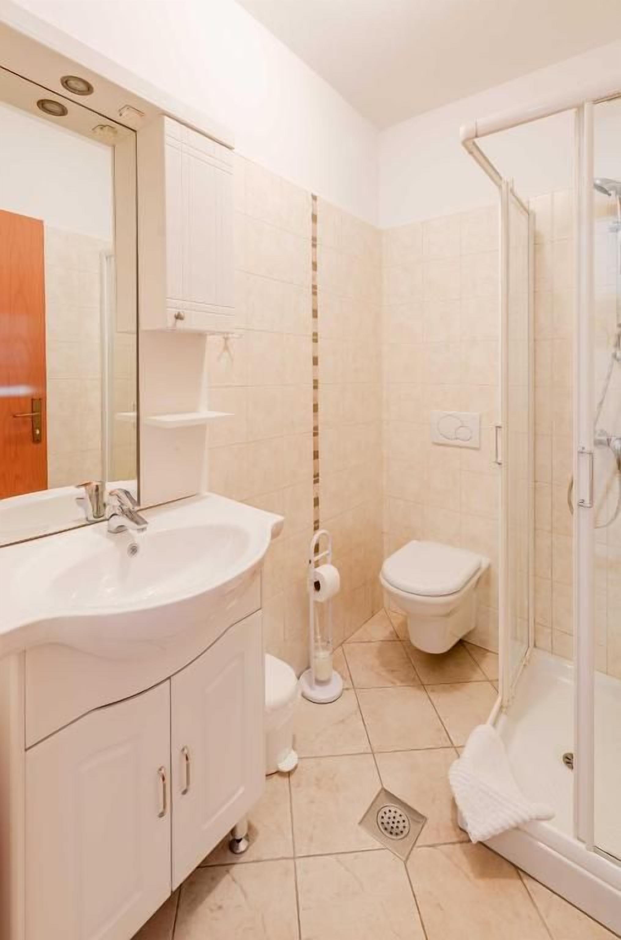 Ein Badezimmer mit Waschbecken, Toilette und Dusche.