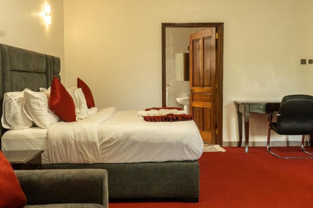 Una habitación de hotel con una cama, un escritorio y una silla.