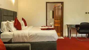 Una habitación de hotel con una cama, un escritorio y una silla.