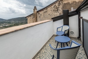 A balcony with a view of a town and mountains, featuring a table and two chairs. - Borgo 1660 - Dimora di Charme (Castellabate)
