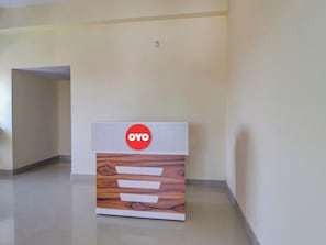 Una recepción con un logotipo, un diseño de paneles de madera y un pasillo limpio y vacío.
