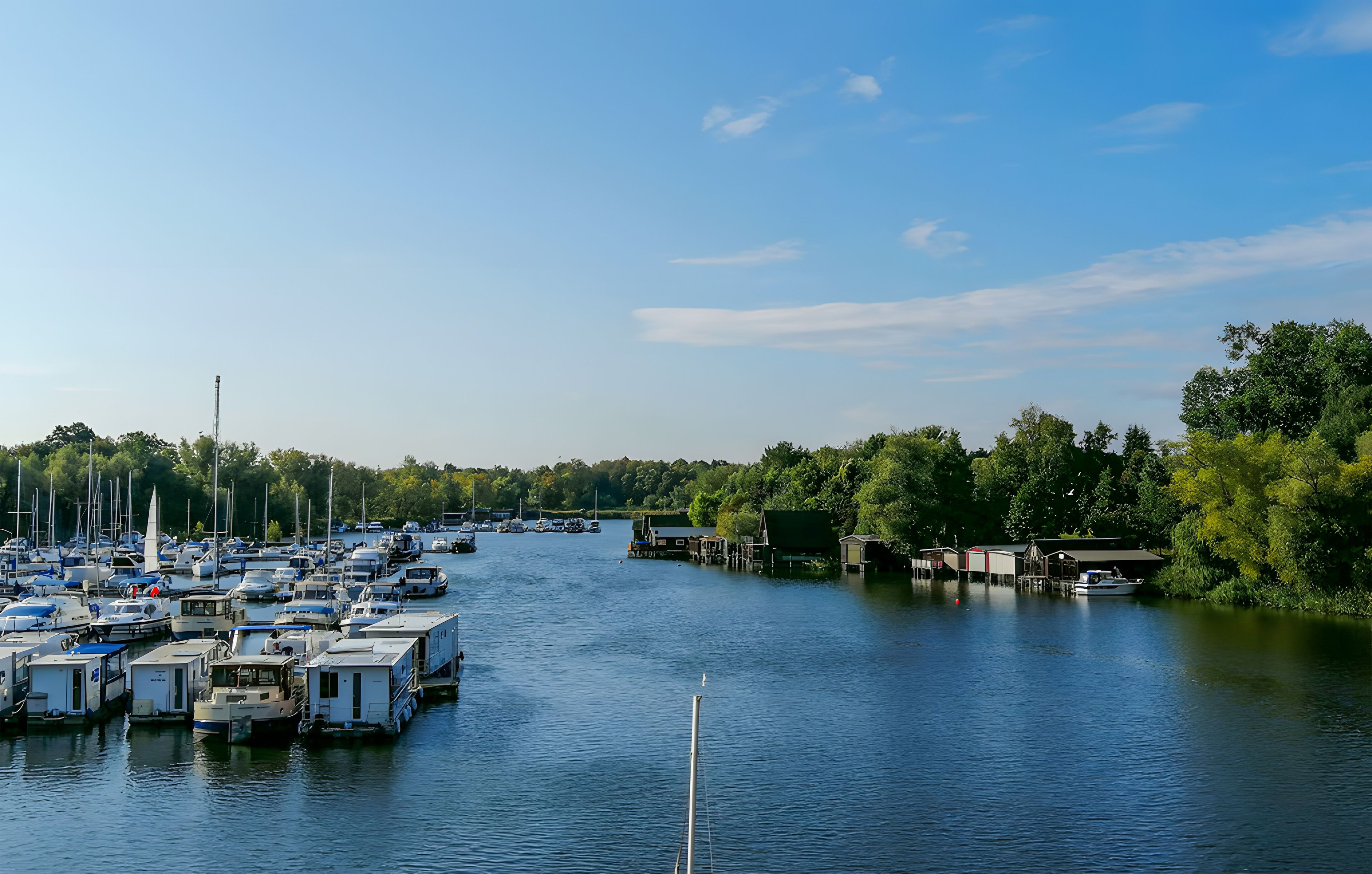 A marina with boats docked and a bridge in the background.