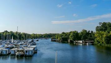 A marina with boats docked and a bridge in the background.