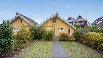 Une rangée de maisons jaunes, avec un chemin pavé menant à l’entrée.