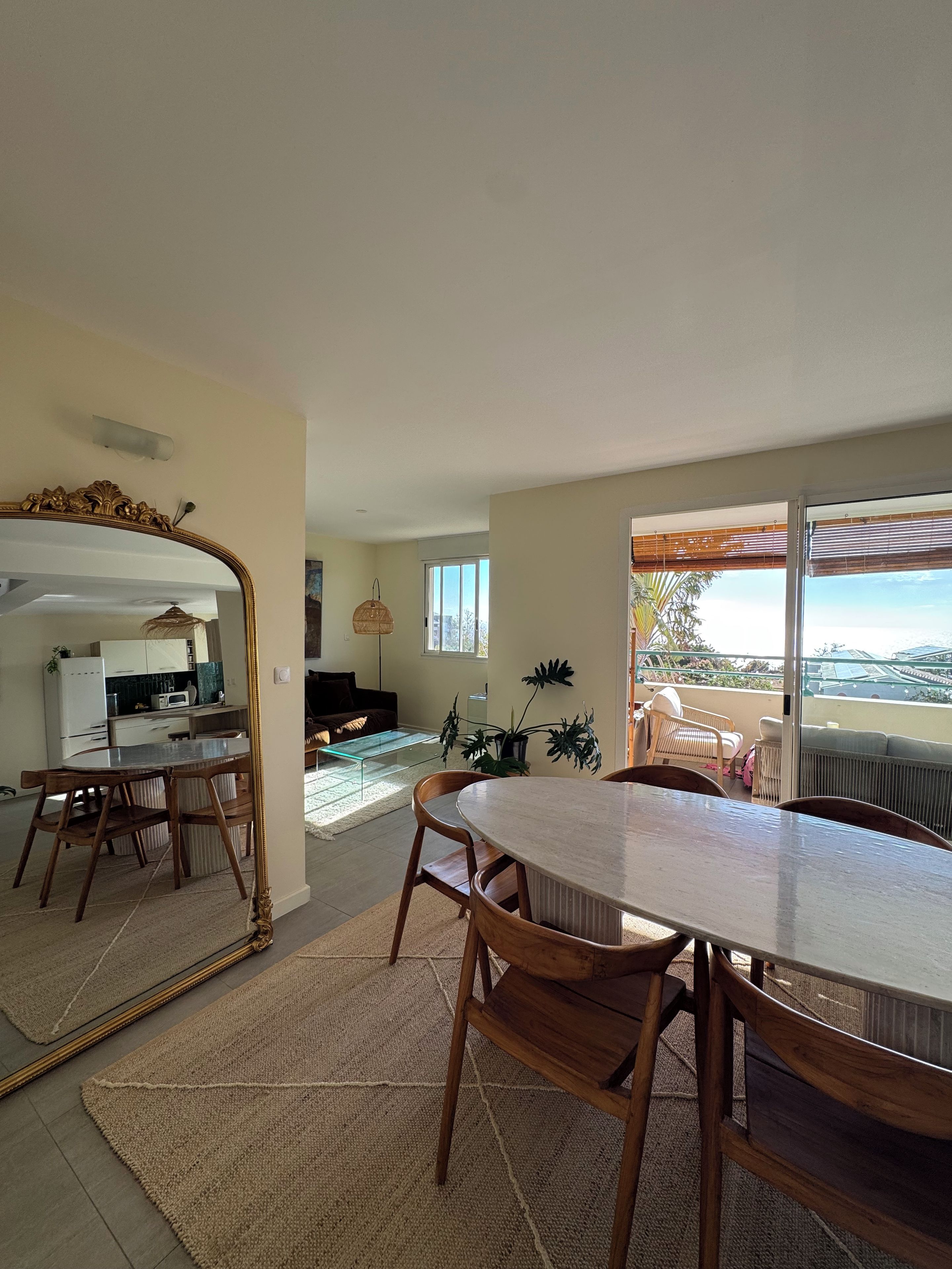 Un salon moderne comprenant un coin repas, une cuisine et un balcon avec vue.