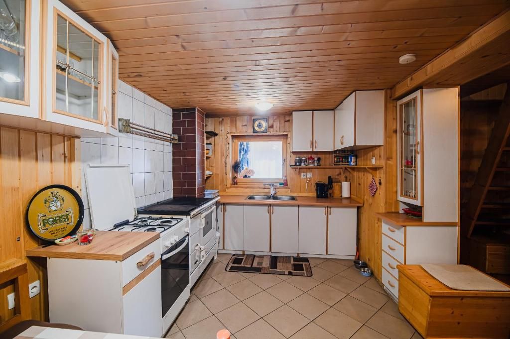 Una cocina pequeña con muebles de madera, cocina a gas y ventana.