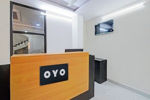 A reception desk with a sign that reads 'OYO' in a modern office setting.