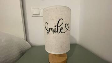 Een lamp met een lampenkap met een structuur en het woord 'smile' erop.
