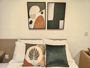 A hotel room with a bed, pillows, and two abstract paintings on the wall. - Makai Acqua Resort (Ipojuca)