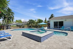 A swimming pool with a tiled hot tub, lounge chairs, and umbrellas. - Pool Home - Close to Barefoot & Bonita Beaches (Bonita Springs)