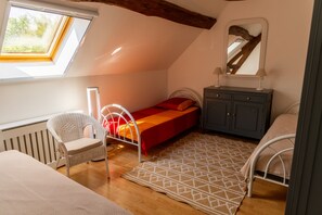 A bedroom with a sloped ceiling, a bed, a chair, a dresser, and a window. - Spacious, charming cottage 'Les Glycines' with Shared Pool, Private Garden and Wi-Fi (Monteaux)