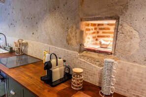 Une cuisine équipée d’un four à briques, d’une machine à café et d’un porte-tasses.