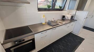 Una cocina moderna con horno, microondas y estufa integrados.