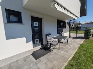 A building with a door, a window, and a patio area with a table and chairs. - Studio Hathor - Bikers Welcome (Kranj)
