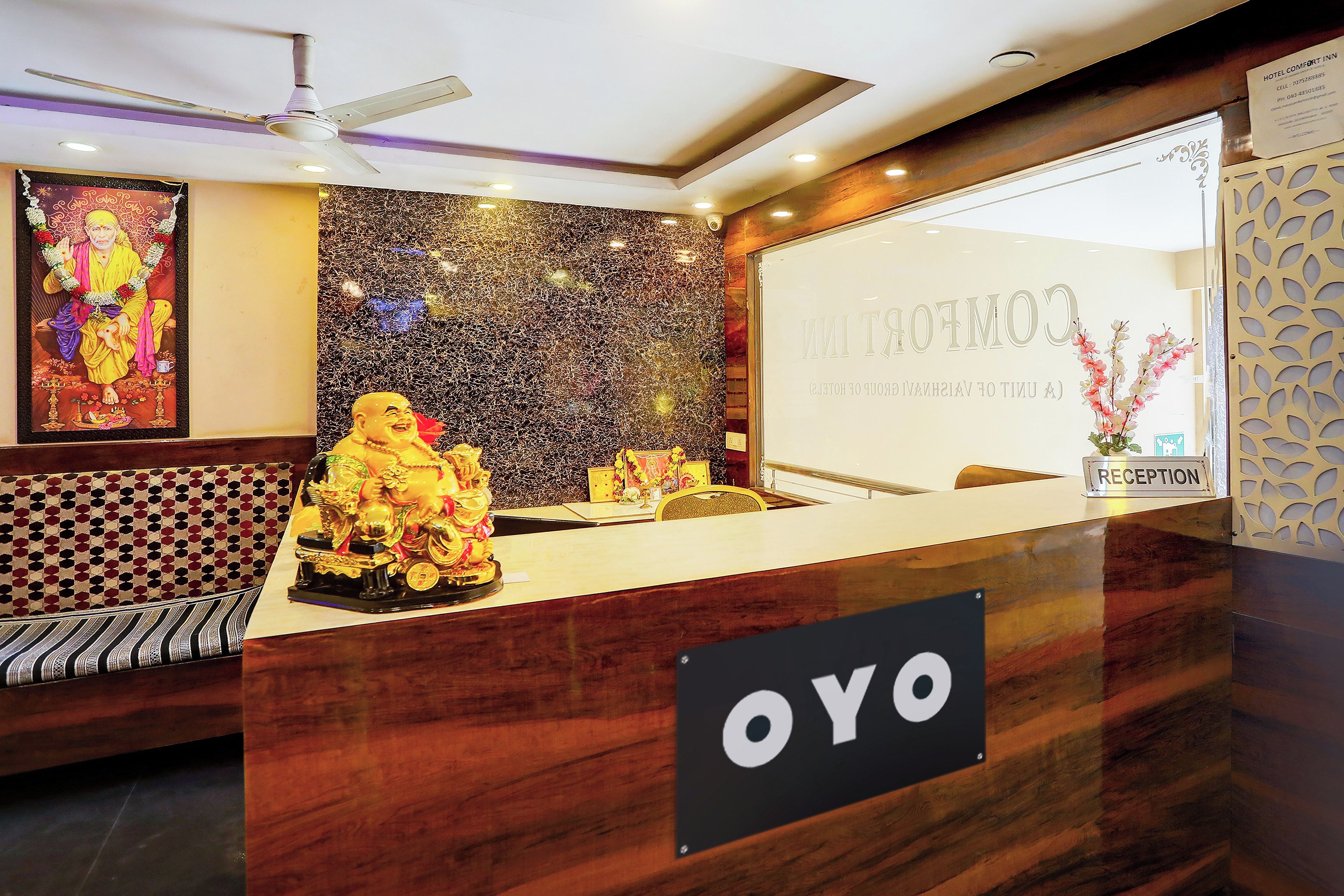 A reception desk with a 'YOYO' sign, a statue, and a wall with a textured pattern.