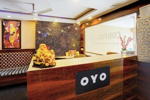 A reception desk with a 'YOYO' sign, a statue, and a wall with a textured pattern. - Hotel O Vaishnavi Inn (Hyderabad)