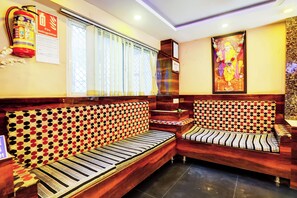 A hotel room with a sofa set, a fire extinguisher, and a wall-mounted certificate. - Hotel O Vaishnavi Inn (Hyderabad)