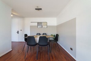 A dining area with a rectangular table, six chairs, and two wall-mounted light fixtures. - Your Serene Getaway Central Providencia (Providencia)