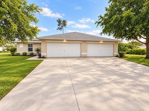 A two-story house with a garage, a driveway, and a lawn. - Spacious 3BR / 2BA Duplex Apartment - Minimum Stay 30 Days (Lehigh Acres)