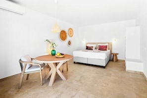 Ein modernes Schlafzimmer mit einem Bett, einem Nachttisch und einem runden Holztisch mit Stühlen.