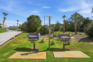 Two barbecue grills with a wooden deck and grass in a park-like setting. - Gulf View, Great Location, Pool, Hot Tub, Tennis (Santa Rosa Beach)