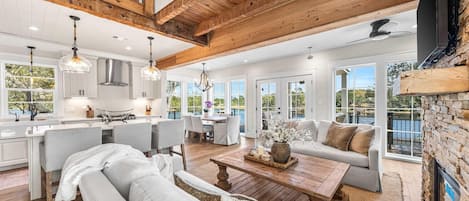A spacious living area with a large wooden ceiling, a dining table, and a sofa.