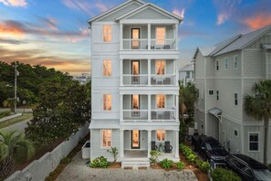 A multi-story residential building with a front porch, a garage, and a driveway. - Serenity by the Sea 30A (Panama City Beach)